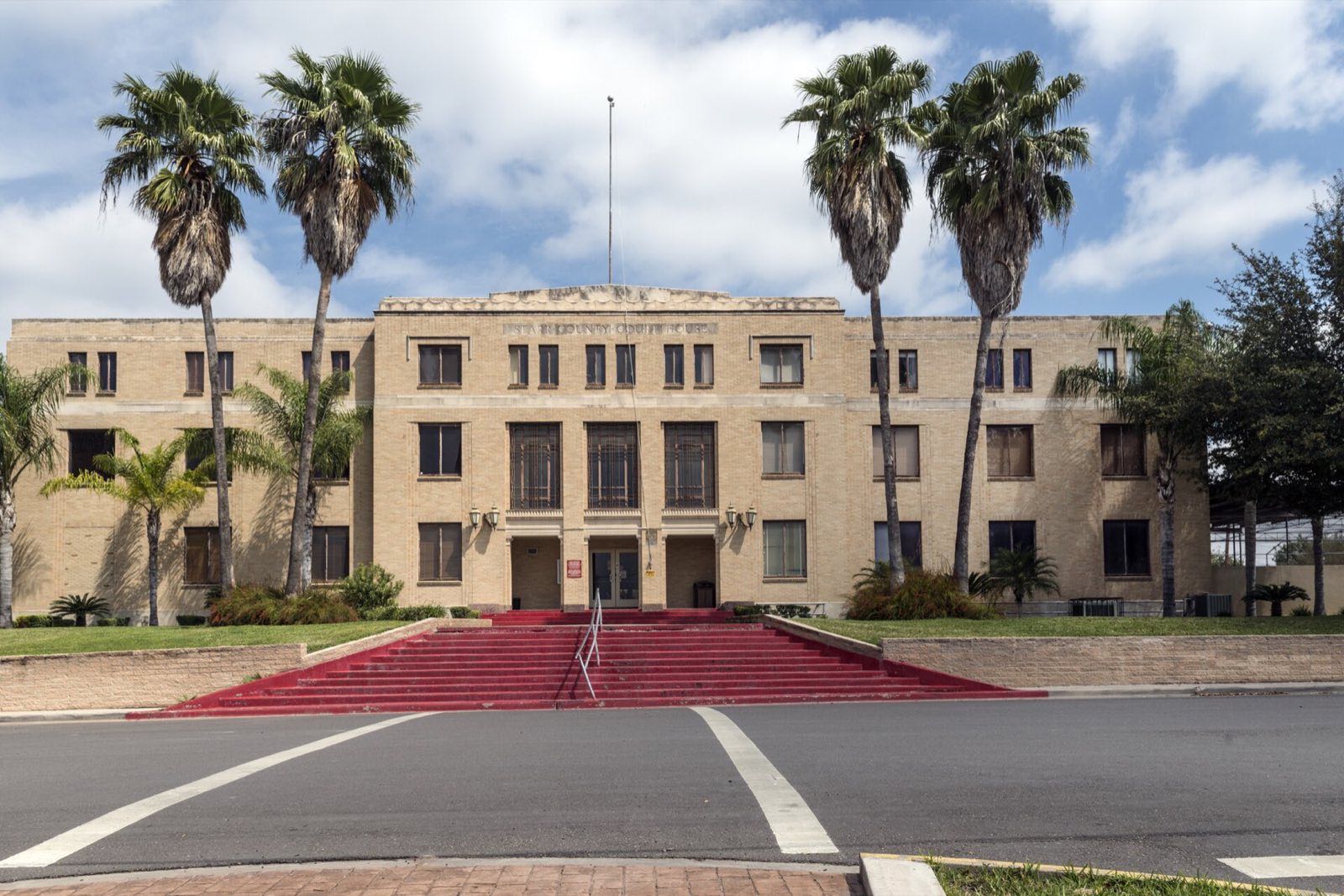 The historic Starr County Courthouse in Rio Grande City, framed by palm trees
